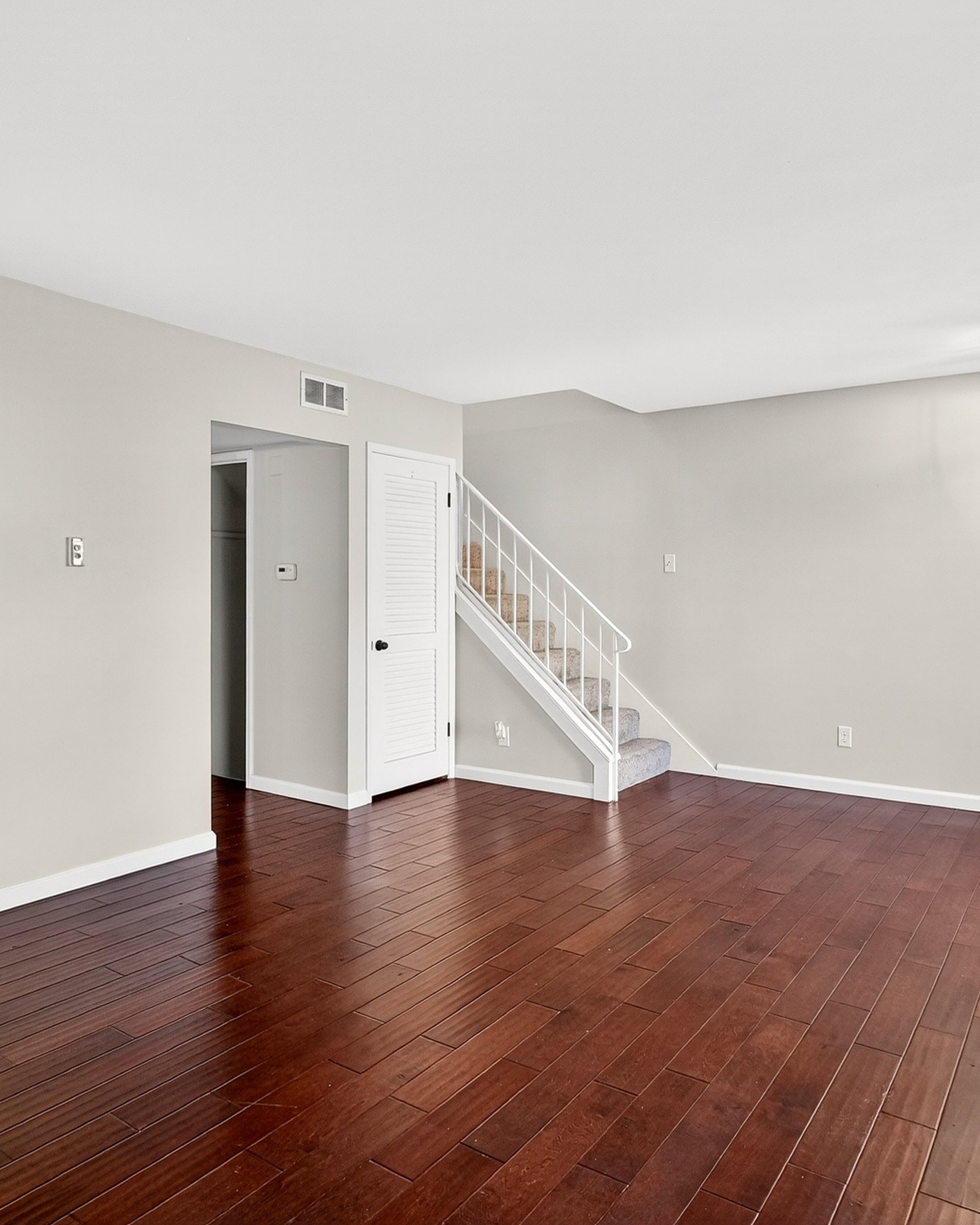 Empty room with wooden floor and staircase