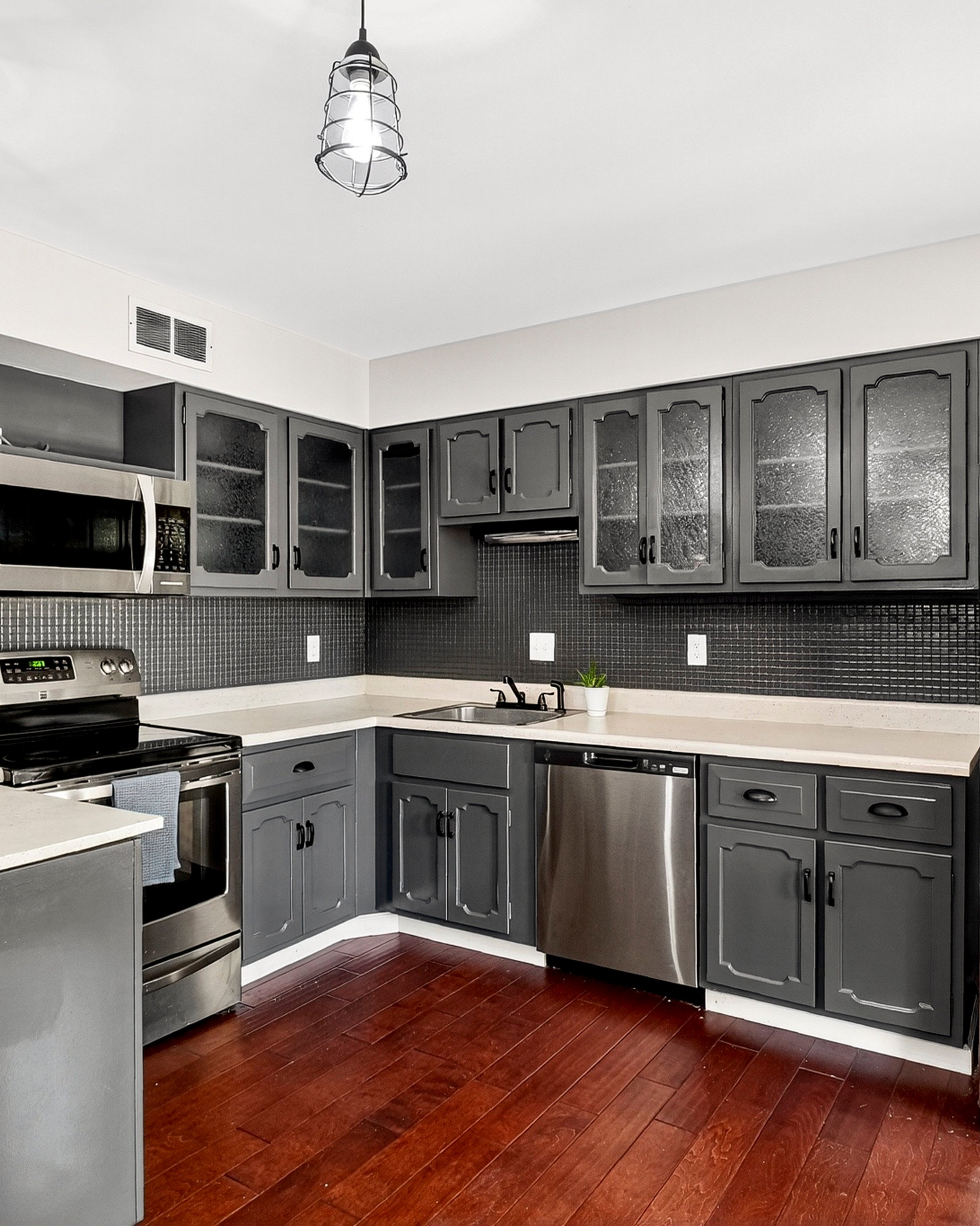 Modern kitchen with stainless steel appliances and gray cabinets.
