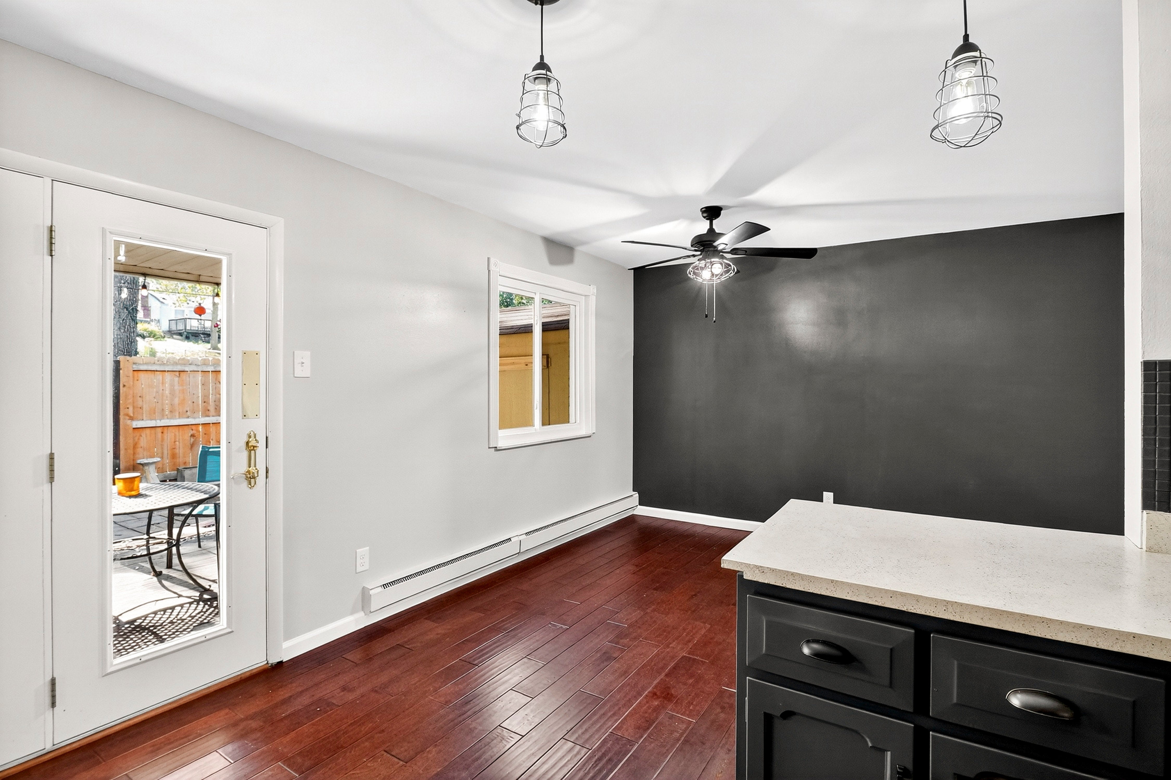 Modern interior of a room with wooden flooring, white walls, and black cabinets.