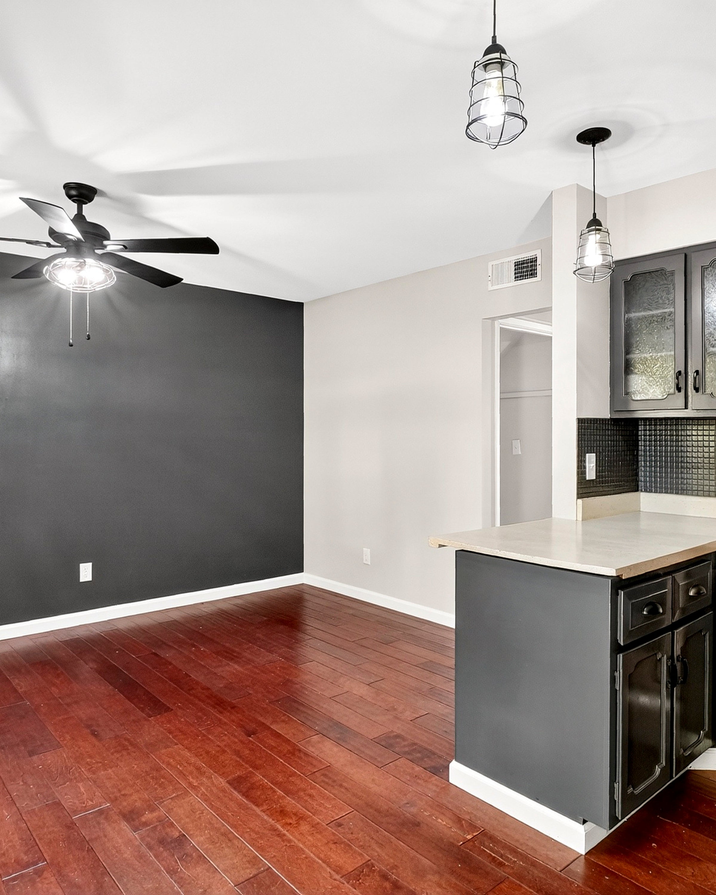 Modern kitchen with stainless steel appliances and a dark gray wall.
