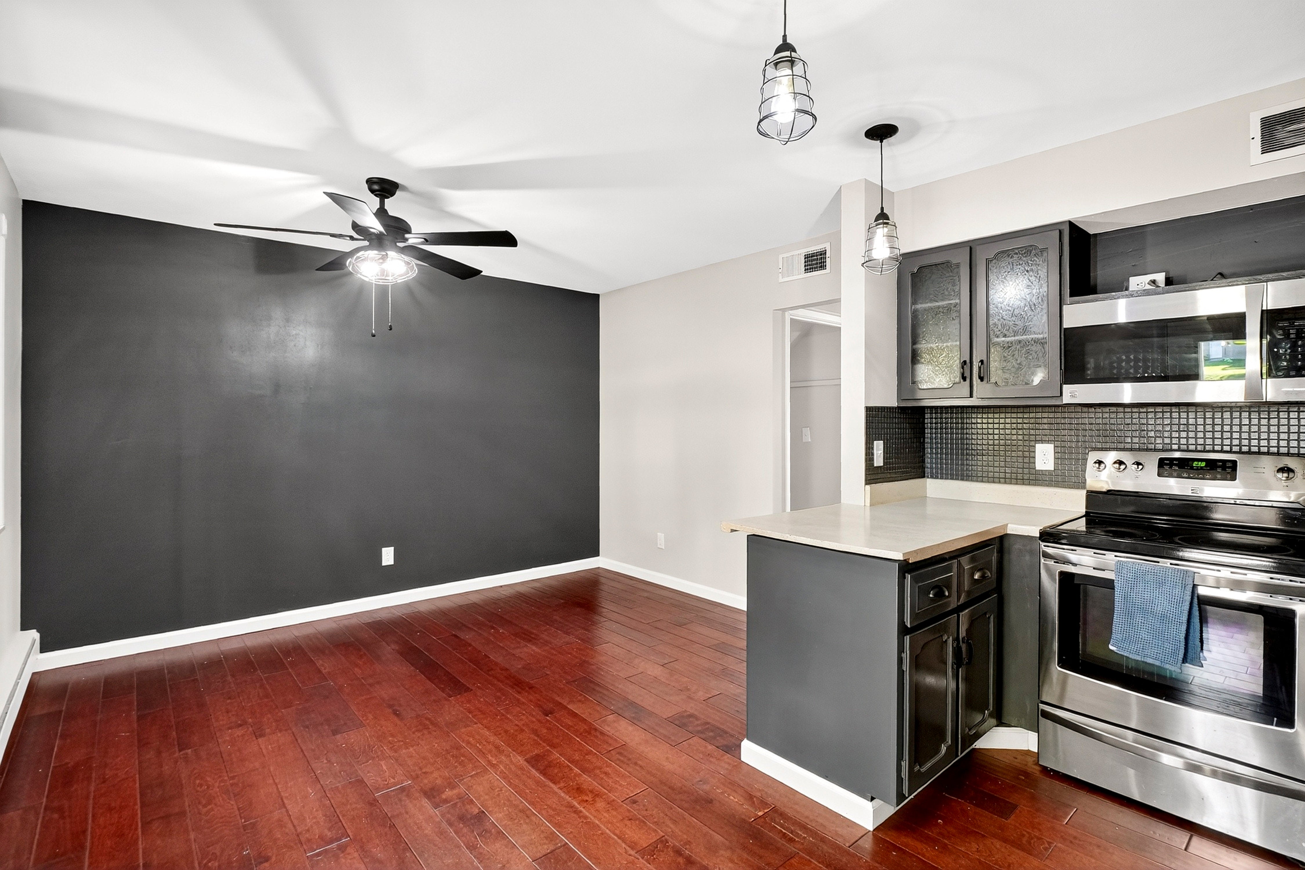 Modern kitchen with stainless steel appliances and a dark gray wall.