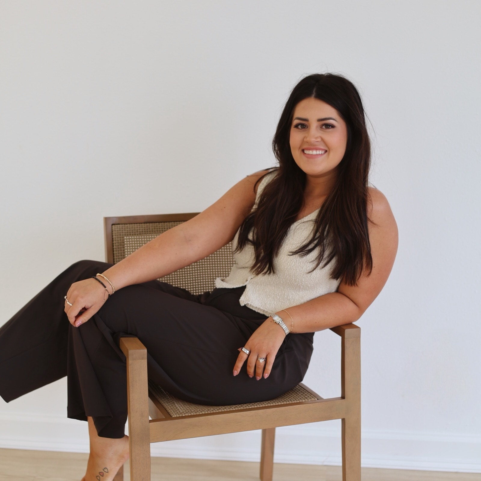 Woman sitting on a chair against a white wall