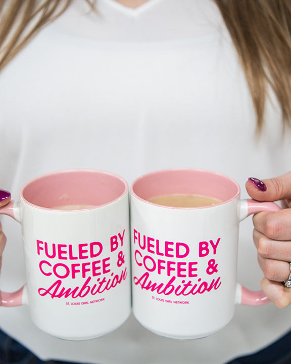 Person holding two mugs with 'Fueled by Coffee & Ambition' text.