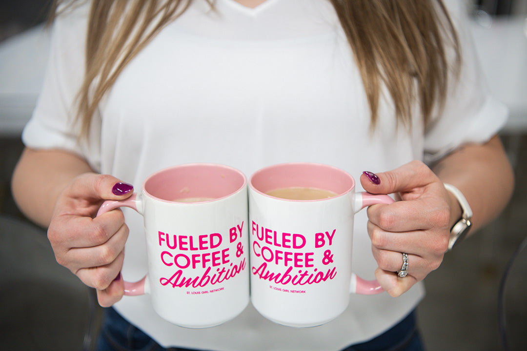 Person holding two mugs with 'Fueled by Coffee & Ambition' text.