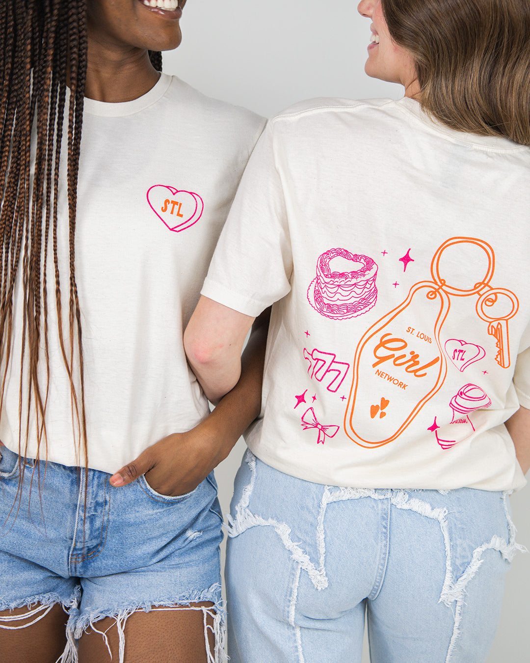 Two people wearing beige t-shirts with colorful graphics and text.