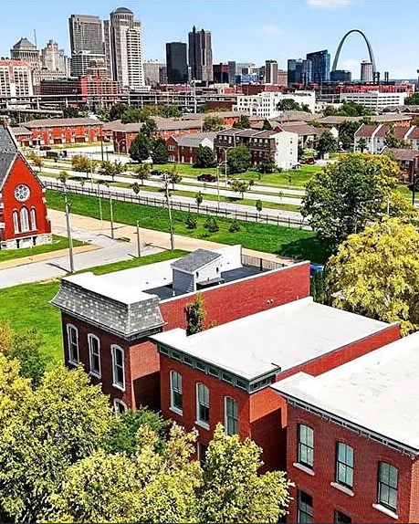 Aerial view of a cityscape with red brick buildings and a distant skyline.