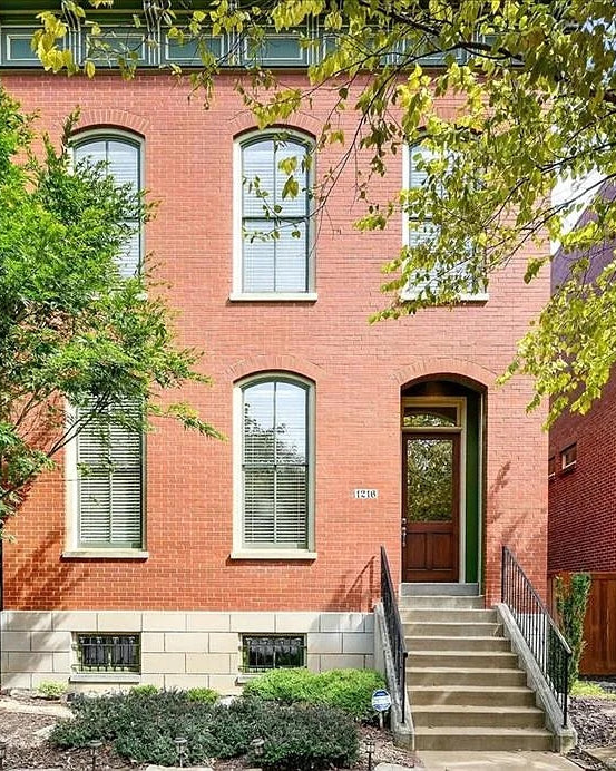 Red brick house with a staircase and greenery