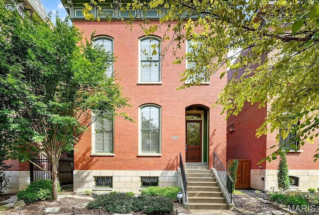 Red brick house with a staircase and greenery
