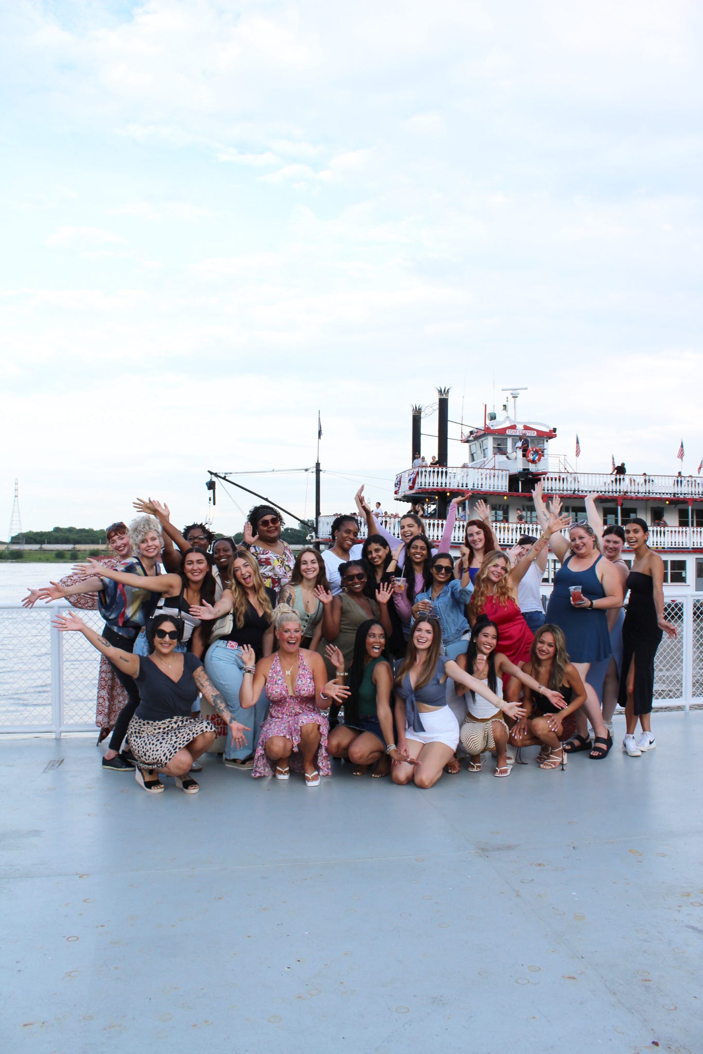 Group of people posing for a photo on a boat with a scenic background