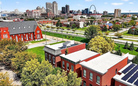 Aerial view of a cityscape with red brick buildings and a distant skyline.