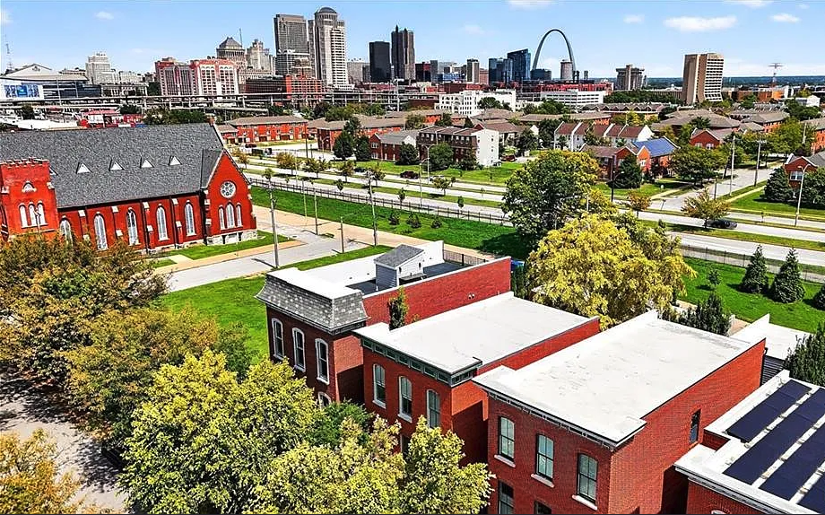 Aerial view of a cityscape with red brick buildings and a distant skyline.